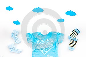 Newborn baby`s sleep concept. To put the child to bed. Baby bodysuit near clouds and cbaby accessories on white