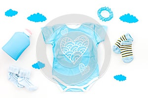 Newborn baby`s sleep concept. To put the child to bed. Baby bodysuit near clouds and cbaby accessories on white