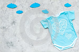 Newborn baby`s sleep concept. To put the child to bed. Baby bodysuit near clouds on grey background top view copy space