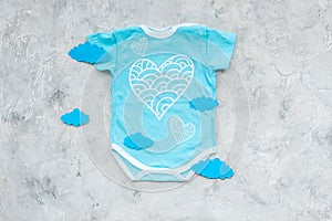 Newborn baby`s sleep concept. To put the child to bed. Baby bodysuit near clouds on grey background top view copy space