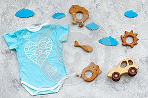 Newborn baby`s sleep concept. To put the child to bed. Baby bodysuit near clouds and toys on grey background top view