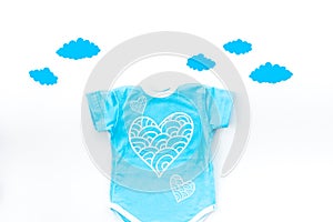 Newborn baby`s sleep concept. To put the child to bed. Baby bodysuit near clouds on white background top view