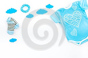 Newborn baby`s sleep concept. To put the child to bed. Baby bodysuit near clouds on white background top view copy space