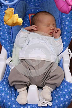 Newborn baby sleeping in baby swing