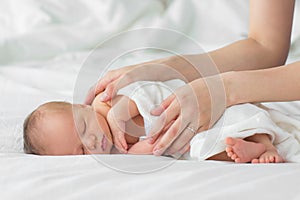 Newborn baby sleeping on a blanket.