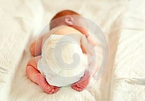 Newborn baby sleeping in a diaper on a changing table.