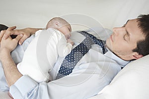 Newborn Baby Sleeping With Father In Bed