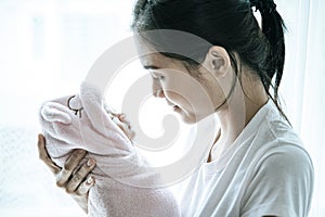 The newborn baby sleeping in the hands of the mother