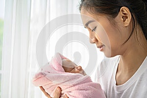 The newborn baby sleeping in the hands of the mother