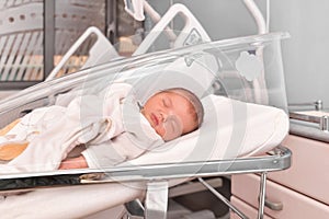 Newborn baby sleeping in the hospital bed