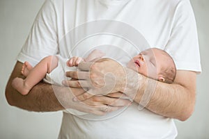 Newborn baby sleeping in mans arms