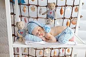 Newborn baby sleeping in a sailor suit in a cap, sea zone, 0-14 days, top view