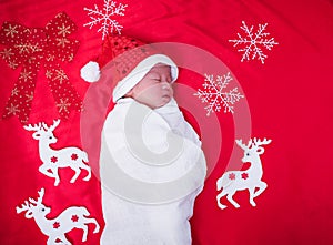 Newborn baby sleeping on santa het and red background,