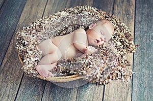 Newborn baby sleeping in wicker basket