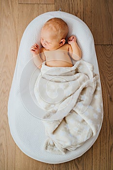 Newborn baby sleeps comfortably in a special orthopedic cocoon mattress. Children and health.