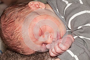 The newborn baby sleeps on the father`s chest concept paternity
