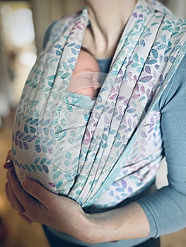 Newborn baby in sling carrier