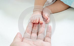 Newborn baby small feet in father`s hand