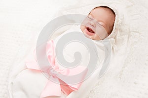 Newborn Baby Smile, New Born Girl Smiling Wrapped by Ribbon Bow