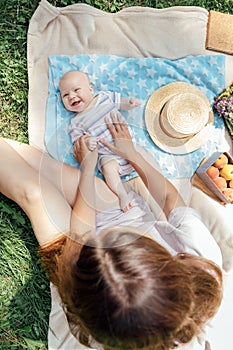 Newborn baby spending time outside. Happy and smiling mother with her newborn baby spending time in the park. Getting