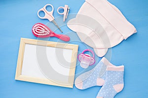 Newborn baby story. Frame with copyspace and children's toys, scissors, baby bottle, nipple, hairbrush on blue background