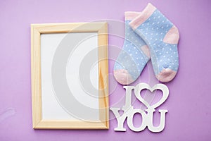 Newborn baby story. Frame with copyspace and children's toys, scissors, baby bottle, nipple, hairbrush on violet background