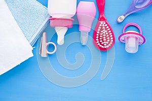 Newborn baby story. Towels and children's toys, scissors, baby bottle, nipple, hairbrush on blue background