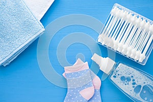 Newborn baby story. Towels and children's toys, scissors, baby bottle, nipple, hairbrush on blue background