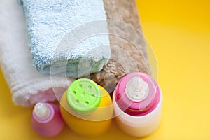 Newborn baby story. Towels and children's toys, scissors, baby bottle, nipple, hairbrush on yellow background