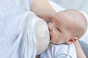 A newborn baby sucks milk from the mother`s breast and falls asleep in her arms, the concept of breastfeeding