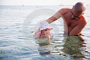 Newborn baby swimming in the sea