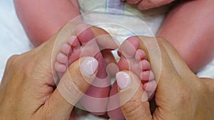 Newborn Baby tiny feet in mother hands. Baby kid feet in parent hand. Happy Family concept. Childhood, infancy