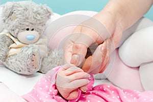 Newborn baby touching his mother hand