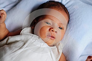 Newborn baby waking up and opening eyes
