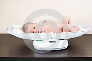 Newborn baby on weighing scale