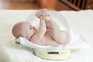 Newborn baby on weighing scale photo