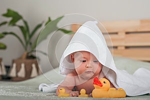 Newborn baby in a white towel. Baby and bathing. Small child care, bathing, ducks