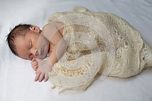 Newborn baby wrapped in a knitted blanket