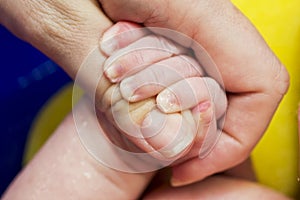 Newborn babys hand holding mothers finger. Taking care of a mother for her child. Family concept. Selected focus