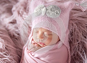 Newborn in beanie hat on a shaggy carpet