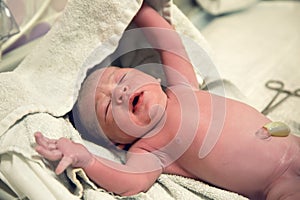 Newborn after birth with umbilical cord lies