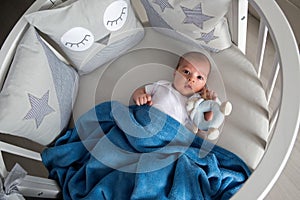 Newborn boy lies in a round bed