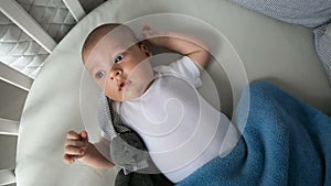 Newborn boy lies in a round bed