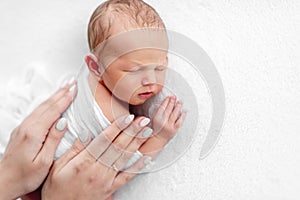 Newborn boy and mother hands