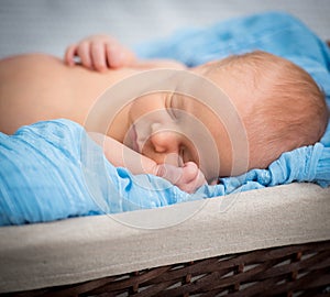 Newborn boy sleeping in a basket