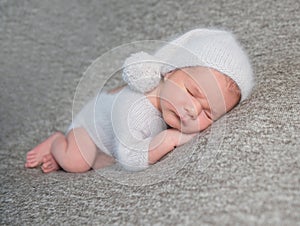 Newborn boy sleeping in funny bonnet