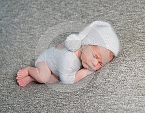 Newborn boy sleeping in funny bonnet