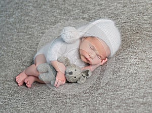 Newborn boy sleeping in funny bonnet