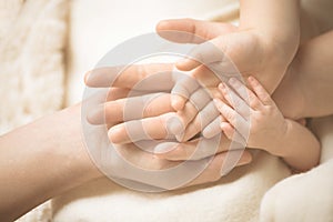 Newborn child hand. Closeup of baby hand into parents hands. Family, maternity and birth concept.