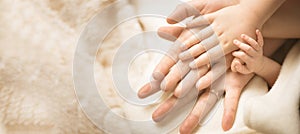 Newborn child hand. Closeup of baby hand into parents hands. Family, maternity and birth concept. Banner